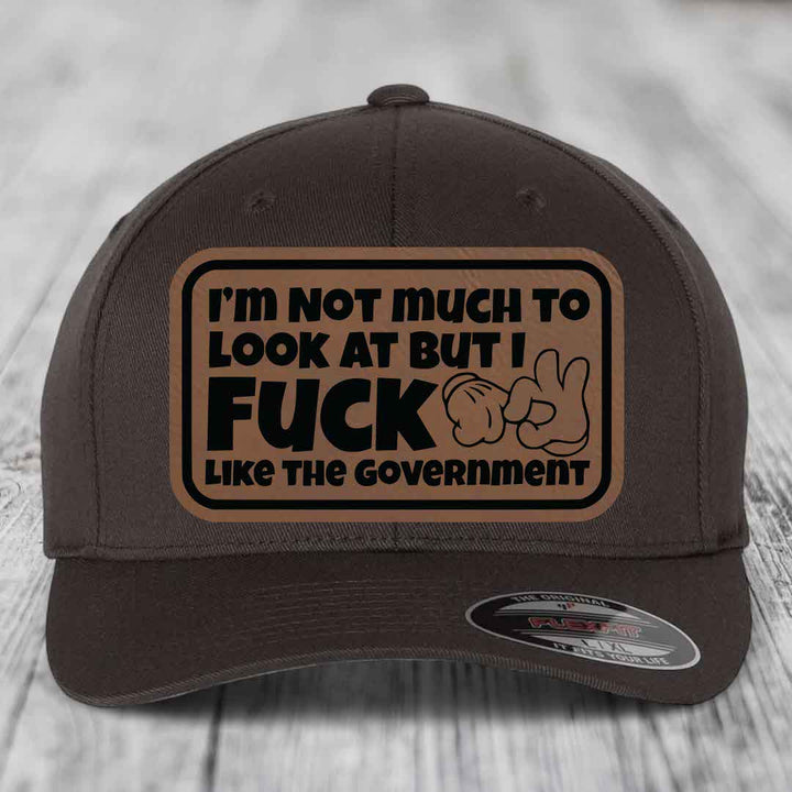 Im Not Much To Look At, But I F*ck Like The Government - Leather Patch Hat - Dark Brown to Black Patch - Flexfit 6277 Fitted Hat