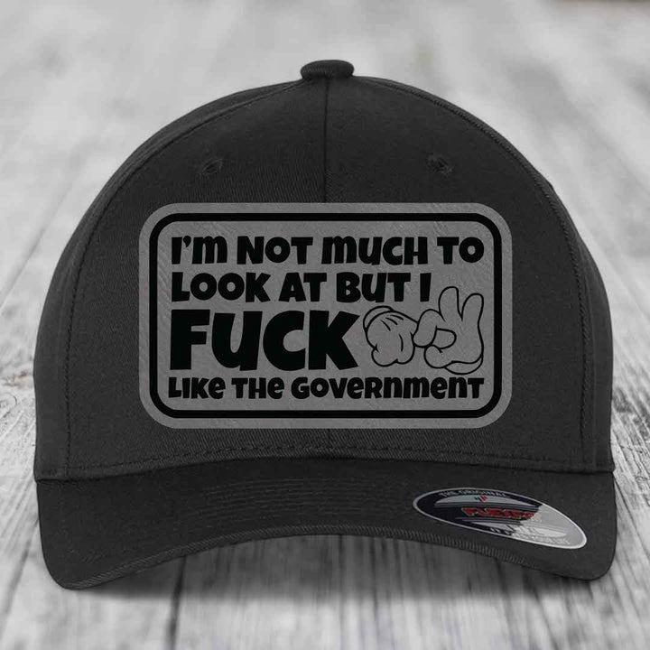 Im Not Much To Look At, But I F*ck Like The Government - Leather Patch Hat - Grey to Black Patch - Flexfit 6277 Fitted Hat