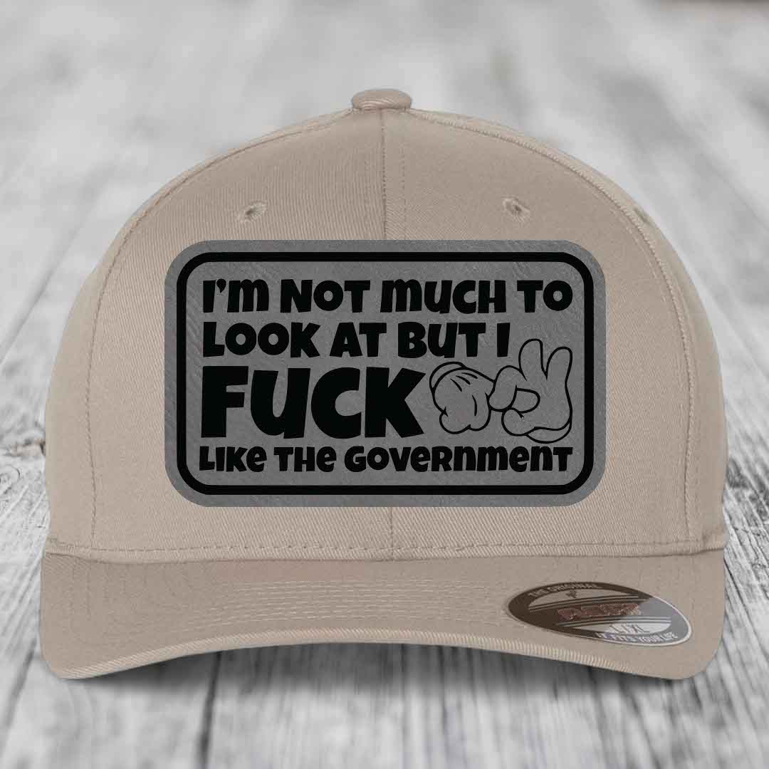 Im Not Much To Look At, But I F*ck Like The Government - Leather Patch Hat - Grey to Black Patch - Flexfit 6277 Fitted Hat