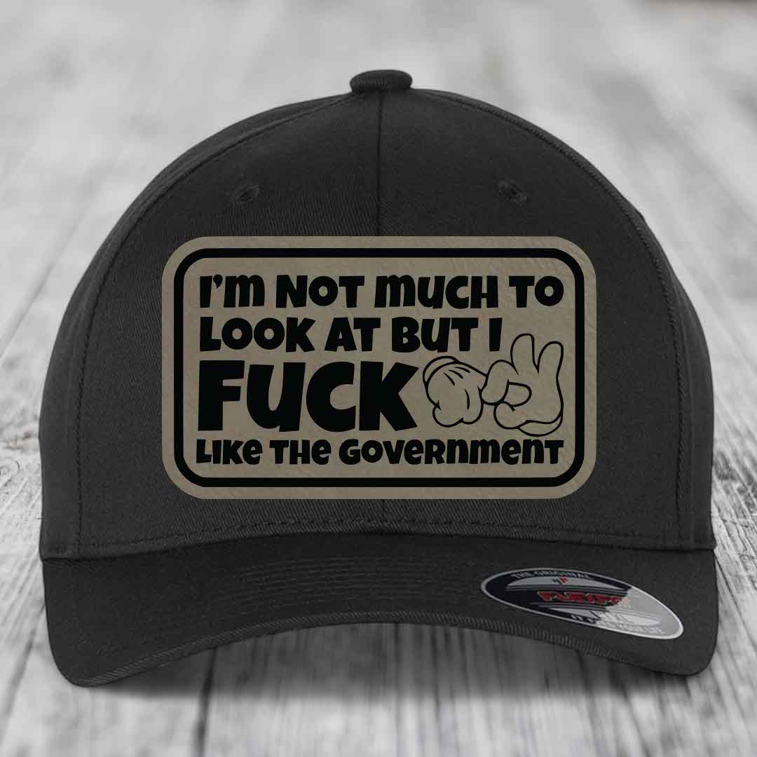 Black baseball cap with rectangular beige patch reading &