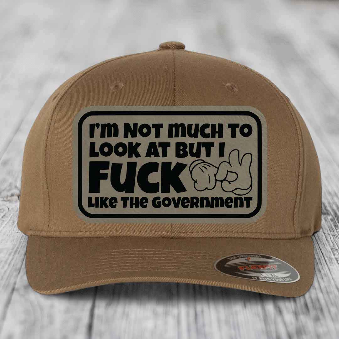Im Not Much To Look At, But I F*ck Like The Government - Leather Patch Hat - Light Brown to Black Patch - Flexfit 6277 Fitted Hat