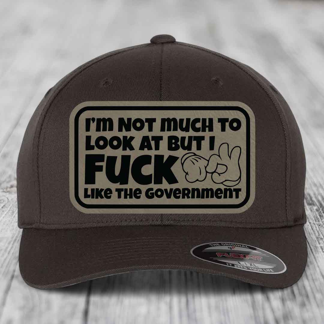 Im Not Much To Look At, But I F*ck Like The Government - Leather Patch Hat - Light Brown to Black Patch - Flexfit 6277 Fitted Hat