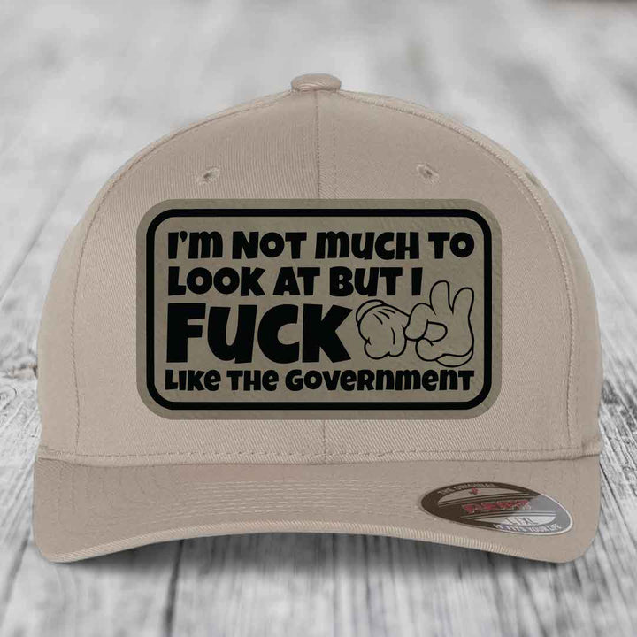 Im Not Much To Look At, But I F*ck Like The Government - Leather Patch Hat - Light Brown to Black Patch - Flexfit 6277 Fitted Hat
