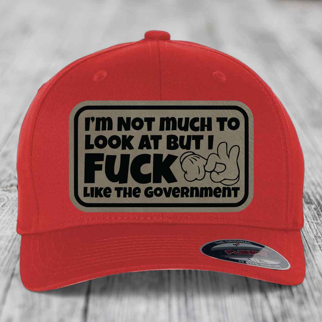 Im Not Much To Look At, But I F*ck Like The Government - Leather Patch Hat - Light Brown to Black Patch - Flexfit 6277 Fitted Hat