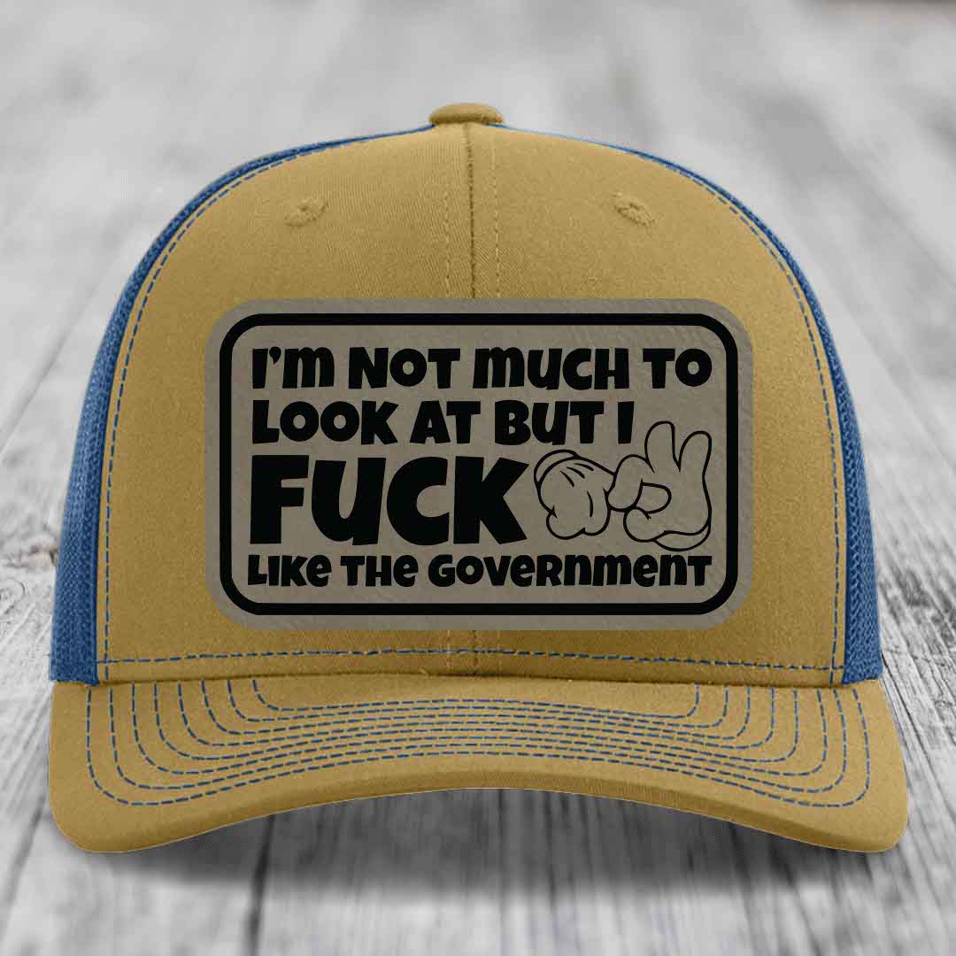 Tan and blue trucker hat with a rectangular patch reading &