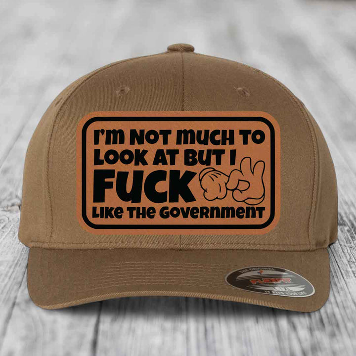 Im Not Much To Look At, But I F*ck Like The Government - Leather Patch Hat - Rawhide to Black Patch - Flexfit 6277 Fitted Hat