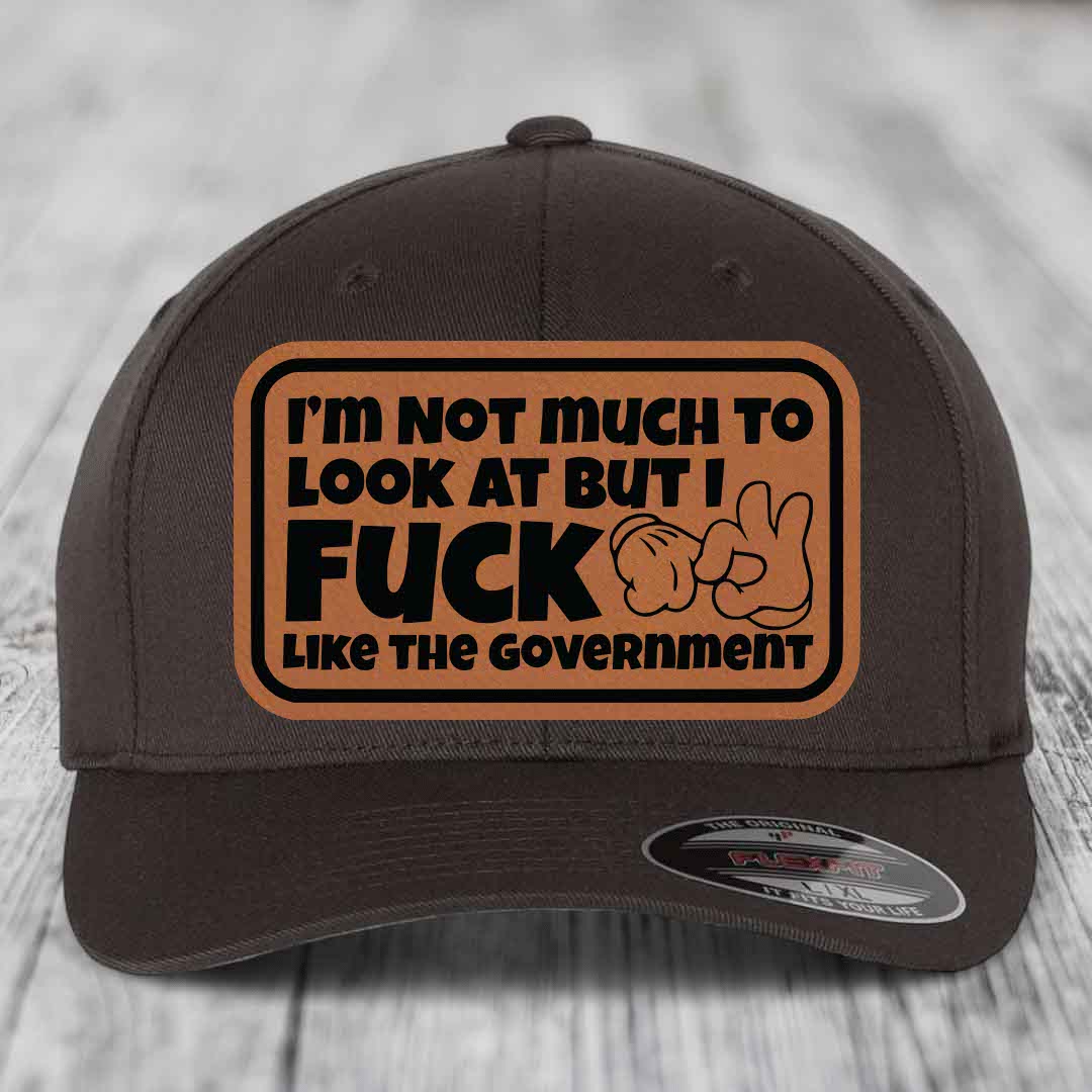 Im Not Much To Look At, But I F*ck Like The Government - Leather Patch Hat - Rawhide to Black Patch - Flexfit 6277 Fitted Hat