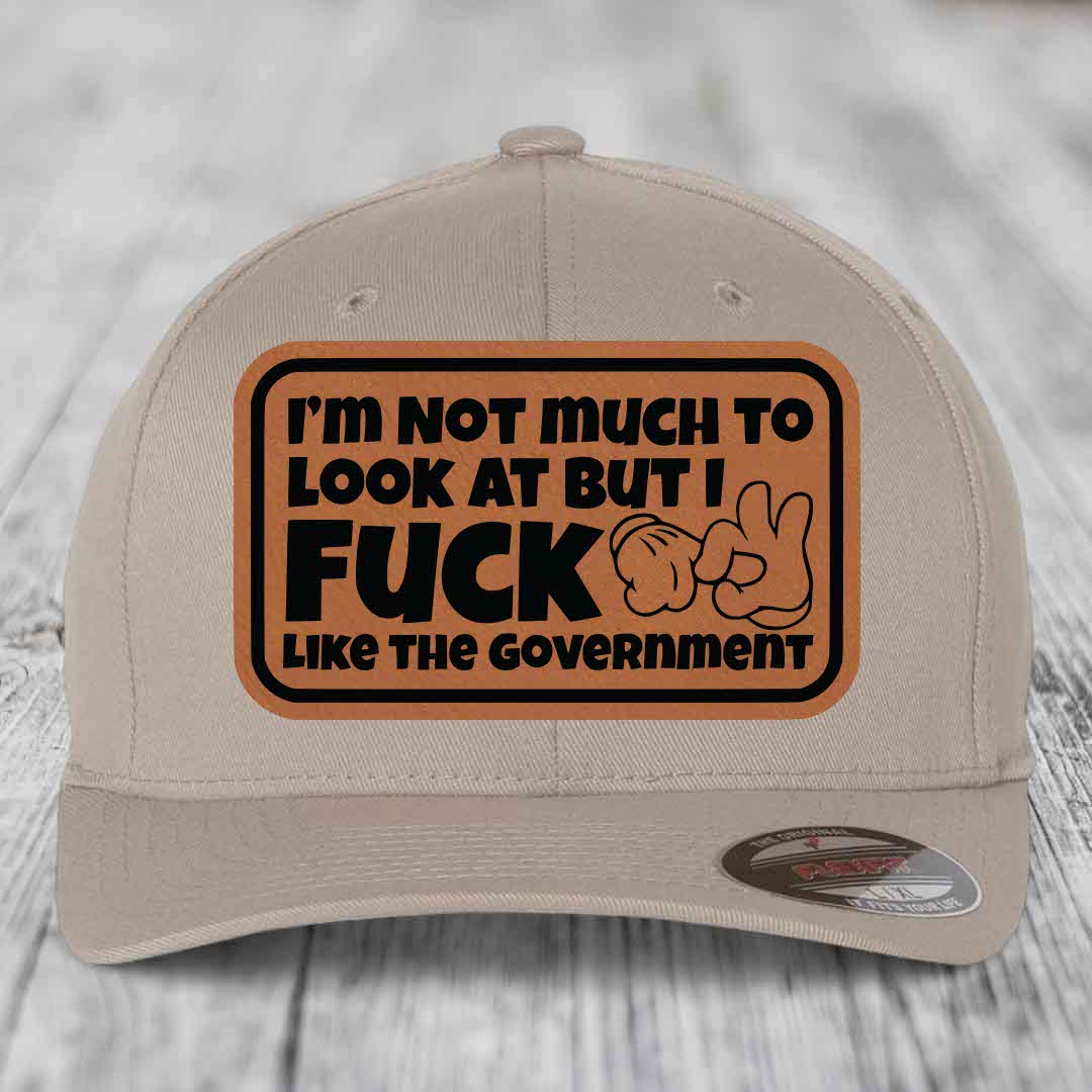 Im Not Much To Look At, But I F*ck Like The Government - Leather Patch Hat - Rawhide to Black Patch - Flexfit 6277 Fitted Hat