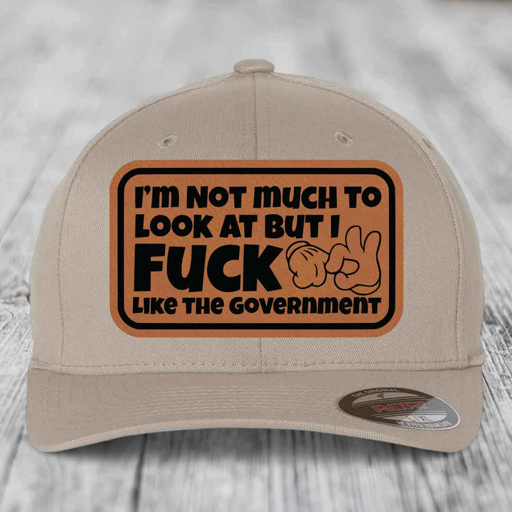 Im Not Much To Look At, But I F*ck Like The Government - Leather Patch Hat - Rawhide to Black Patch - Flexfit 6277 Fitted Hat