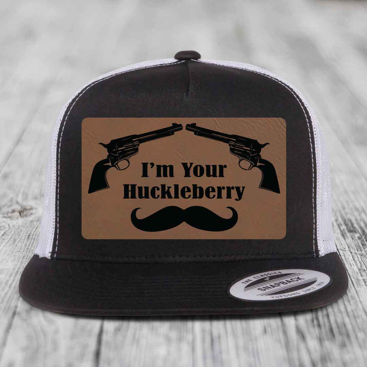 Black and white trucker hat with brown leather patch featuring two revolvers, text &