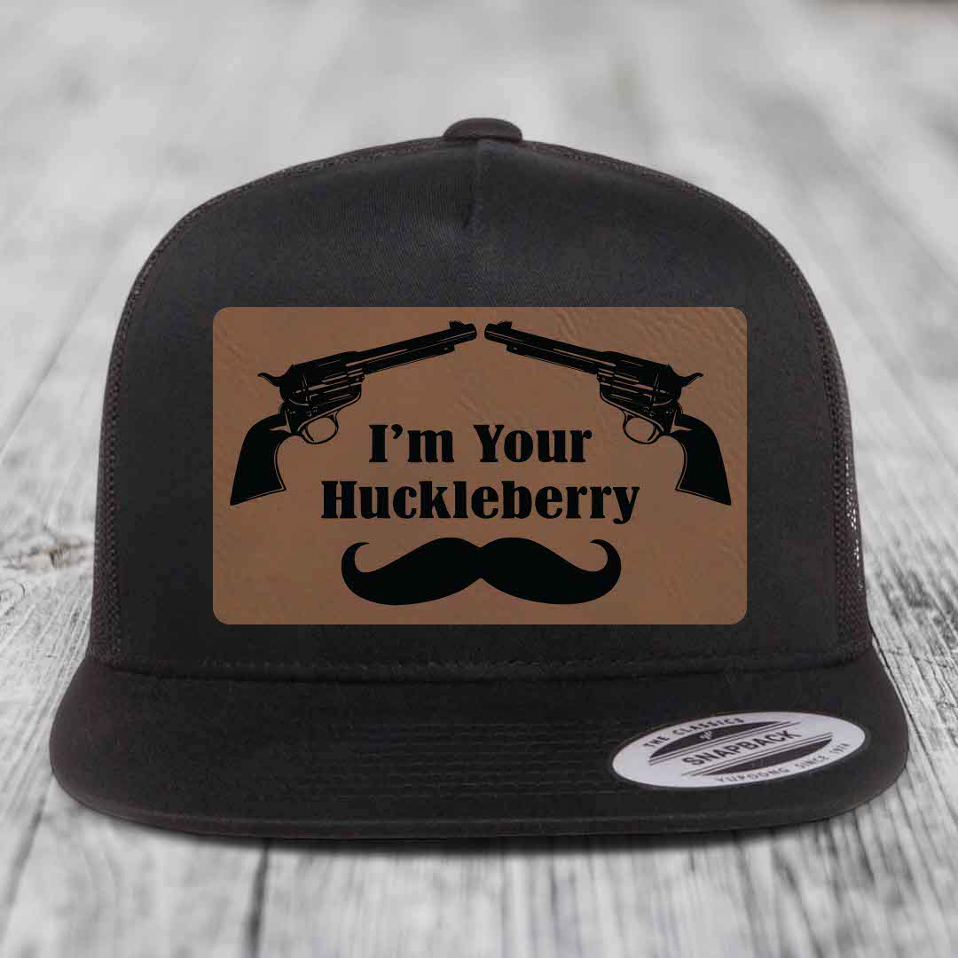 Black snapback hat with brown leather patch featuring two revolvers, text &