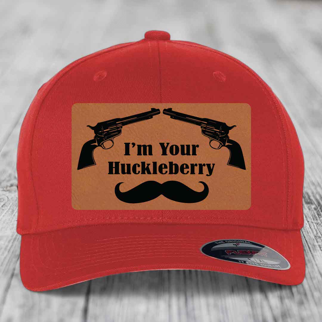 Red baseball cap with brown leather patch featuring two revolvers, text &