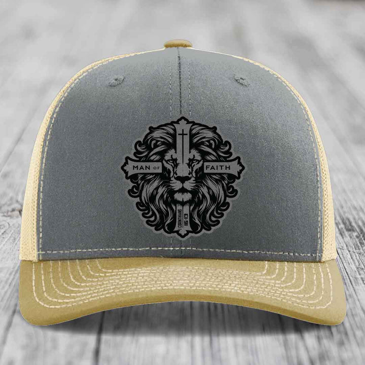 Grey and beige trucker hat with black lion head patch reading &