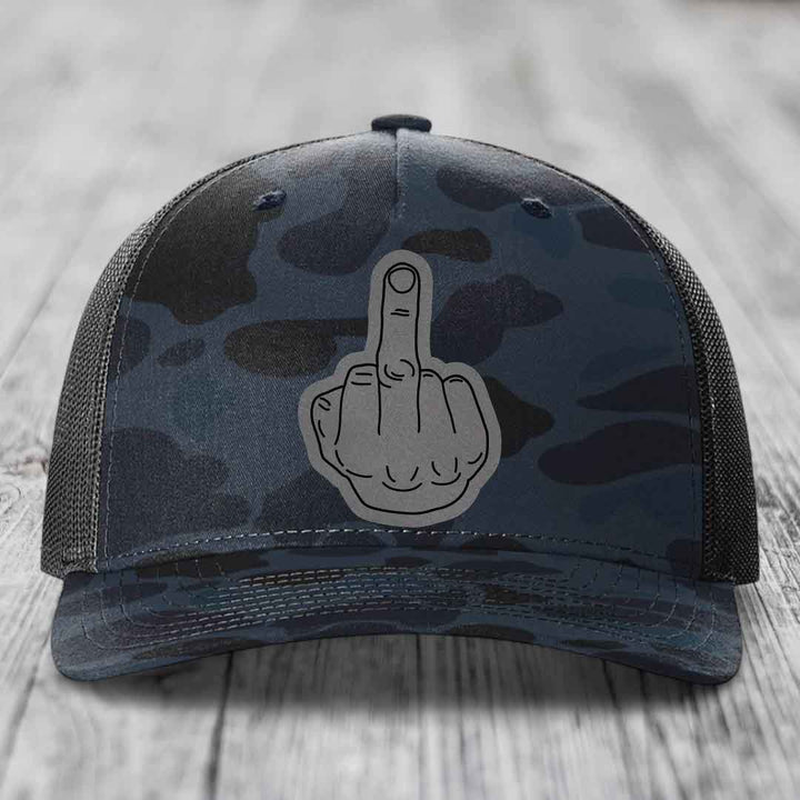 Camouflage trucker hat with a grey middle finger patch on the front.