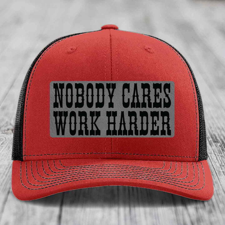Red trucker hat with black mesh back and gray rectangular patch reading &
