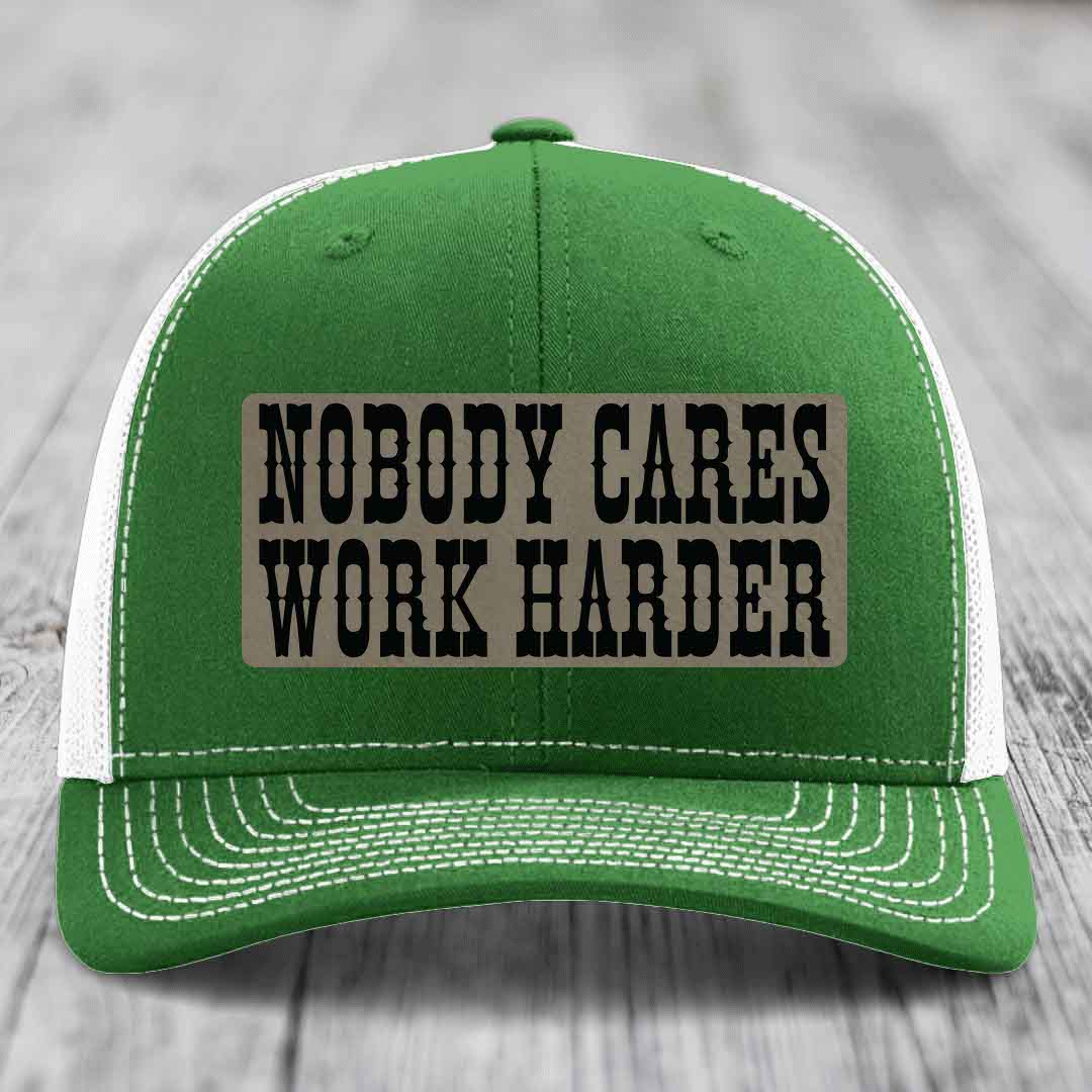 Green trucker hat with white mesh back and brim, featuring a beige leather patch that reads &