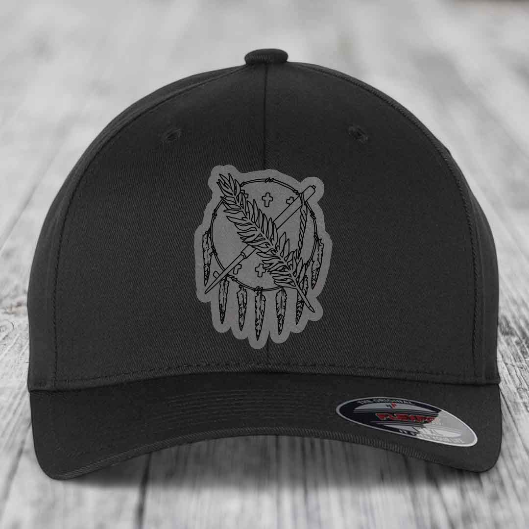 Black baseball cap with grey embroidered dreamcatcher patch featuring feathers and crosses.