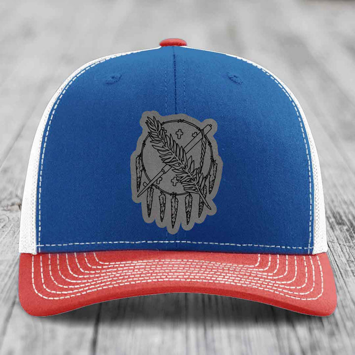 Blue and red trucker hat with grey Oklahoma State flag leather patch on front.