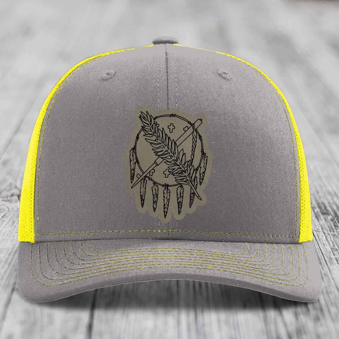 Grey trucker hat with yellow mesh and stitching, featuring a dreamcatcher patch.