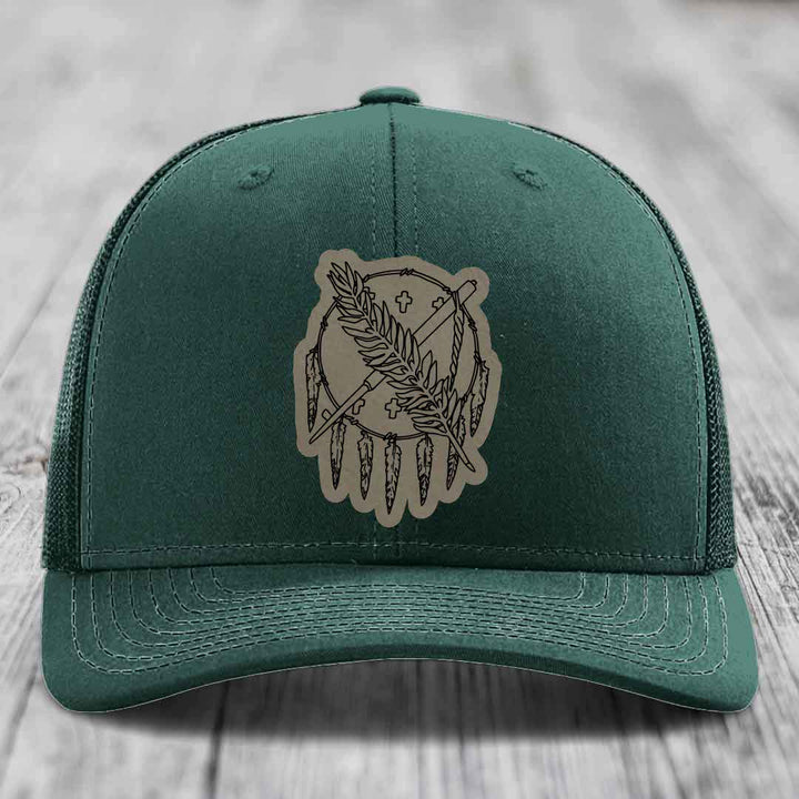 Green trucker hat with beige leather patch featuring dreamcatcher design.