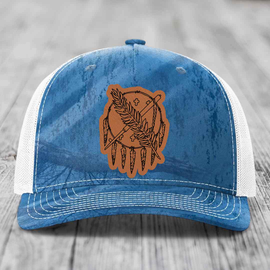 Blue and white trucker hat with brown leather patch featuring dreamcatcher design.