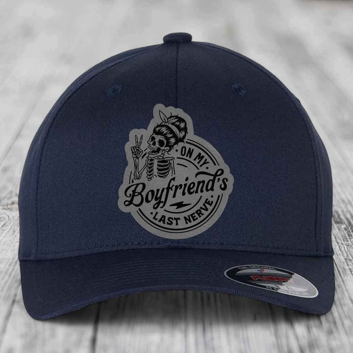 Dark blue baseball cap with a grey patch featuring a skeleton holding peace signs and the text &