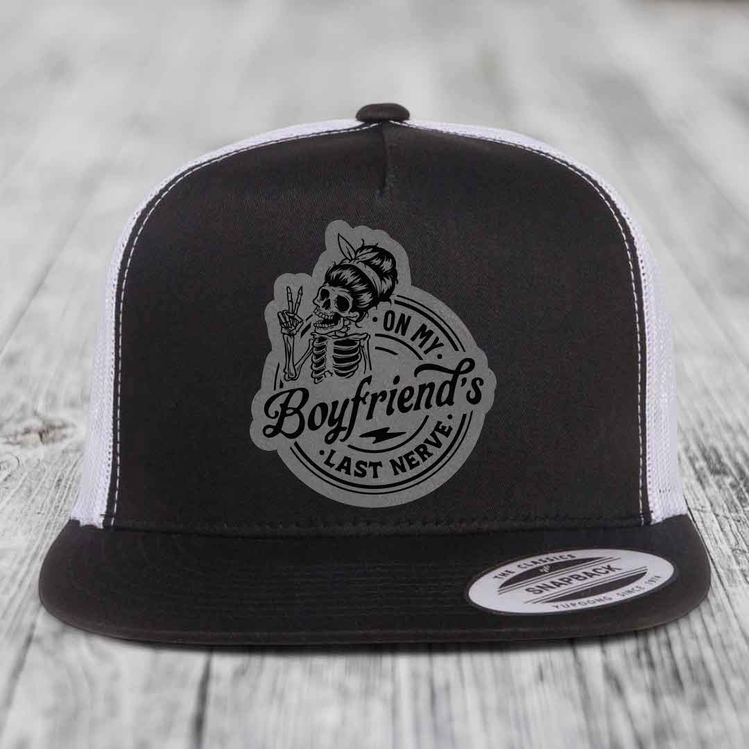 Black and white trucker hat with skeleton graphic patch reading &