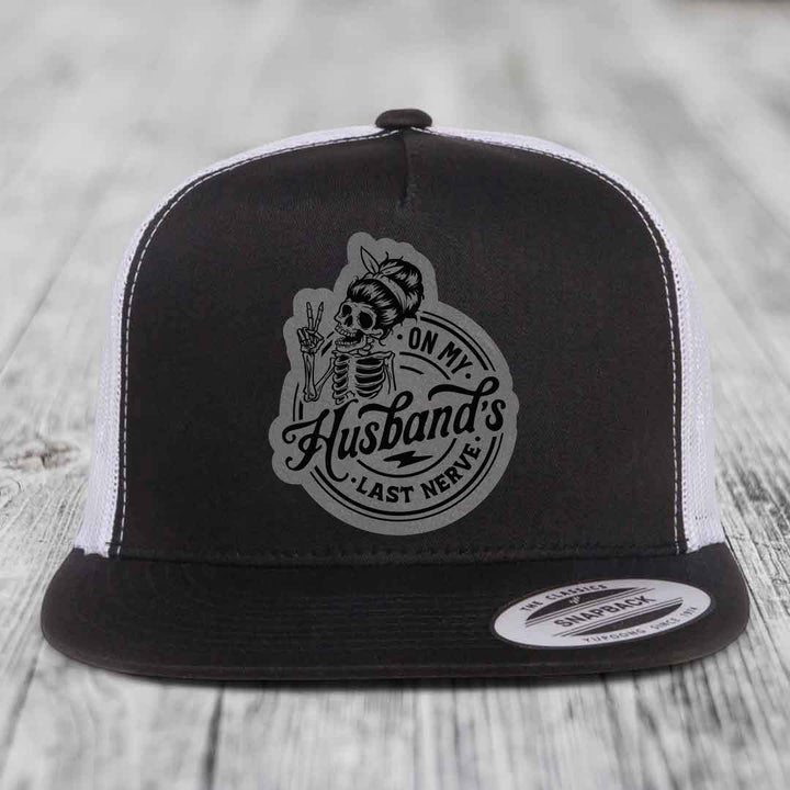 Black and white trucker hat with skeleton graphic patch reading &