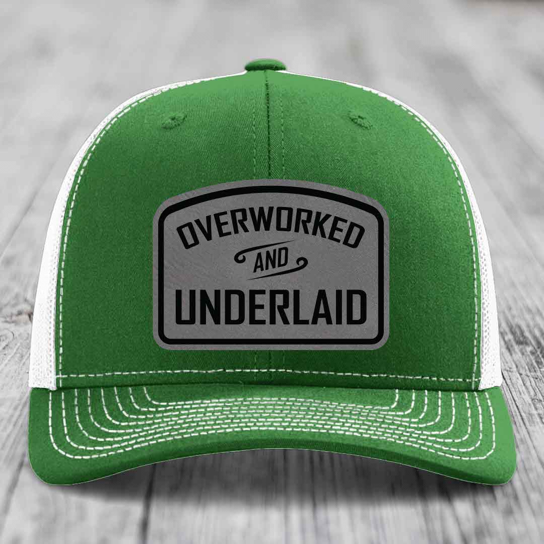 Green trucker hat with white mesh back and gray leatherette patch reading &