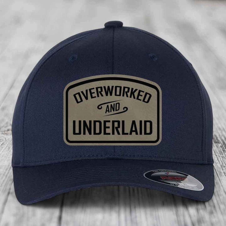 Dark blue baseball cap with a beige leatherette patch reading &