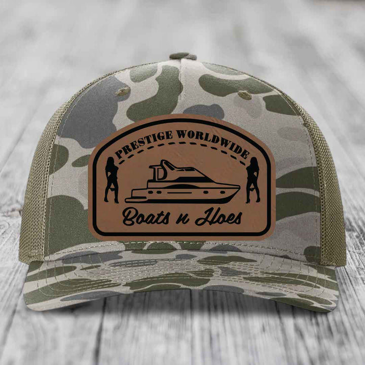 Camouflage trucker hat with brown leather patch featuring &
