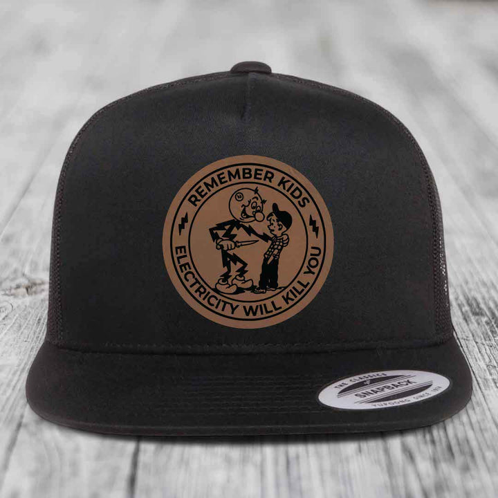 Black snapback hat with brown circular patch showing cartoon characters and text &