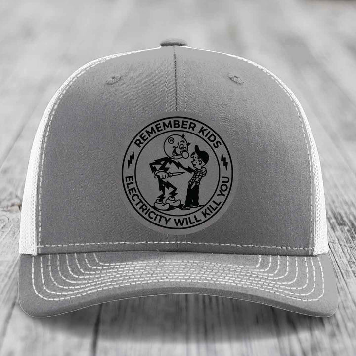 Grey trucker hat with black embroidered patch reading &