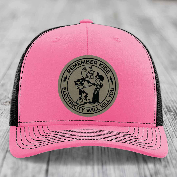 Pink trucker hat with black mesh back and a circular grey patch that reads &