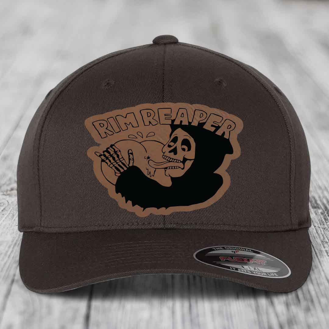 Dark brown Flexfit hat with a tan leatherette patch featuring a skull holding a basketball and the text &
