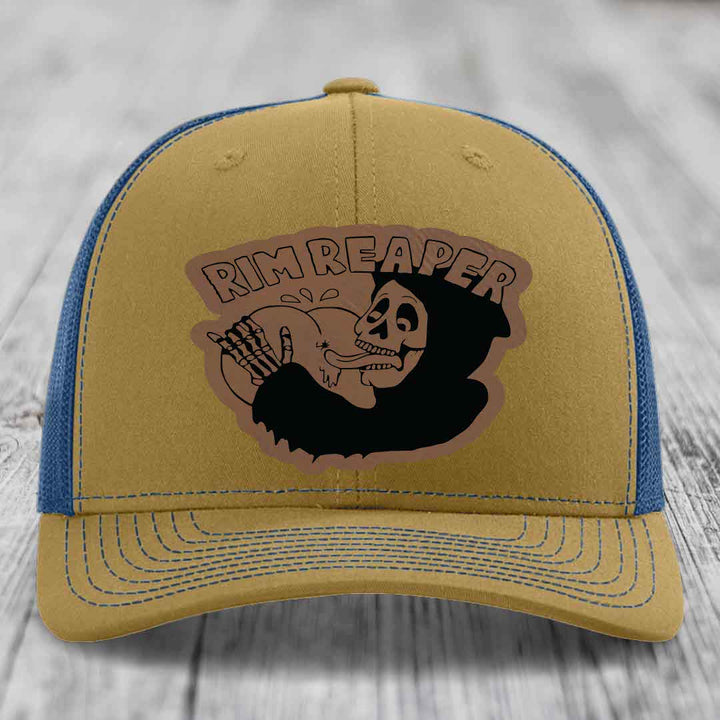 Tan trucker hat with blue mesh back and embroidered &