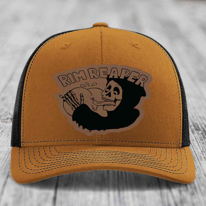 Tan trucker hat with black mesh back and embroidered &
