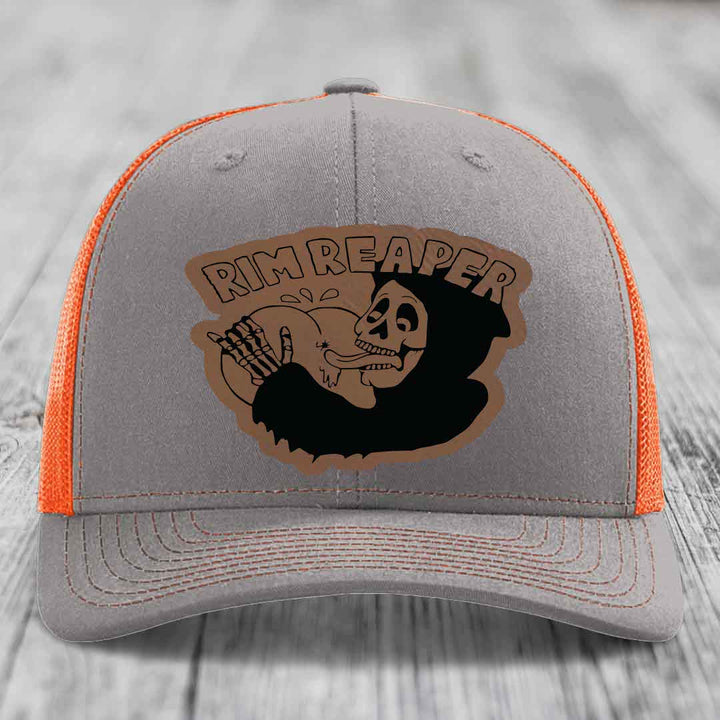 Grey trucker hat with orange mesh back and embroidered &