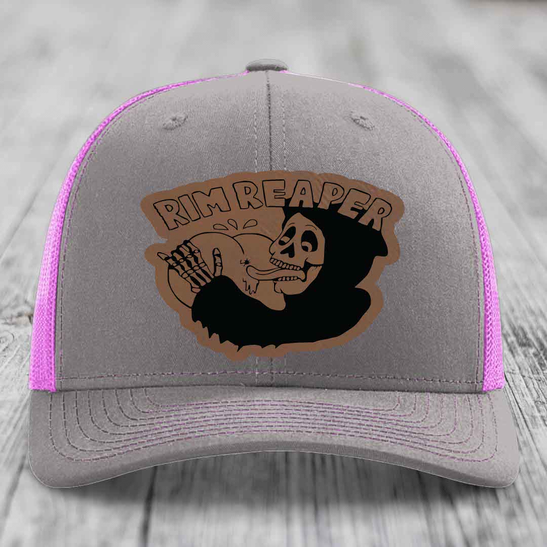 Grey trucker hat with pink mesh sides and a brown leather patch featuring a skeleton holding a basketball and the text &