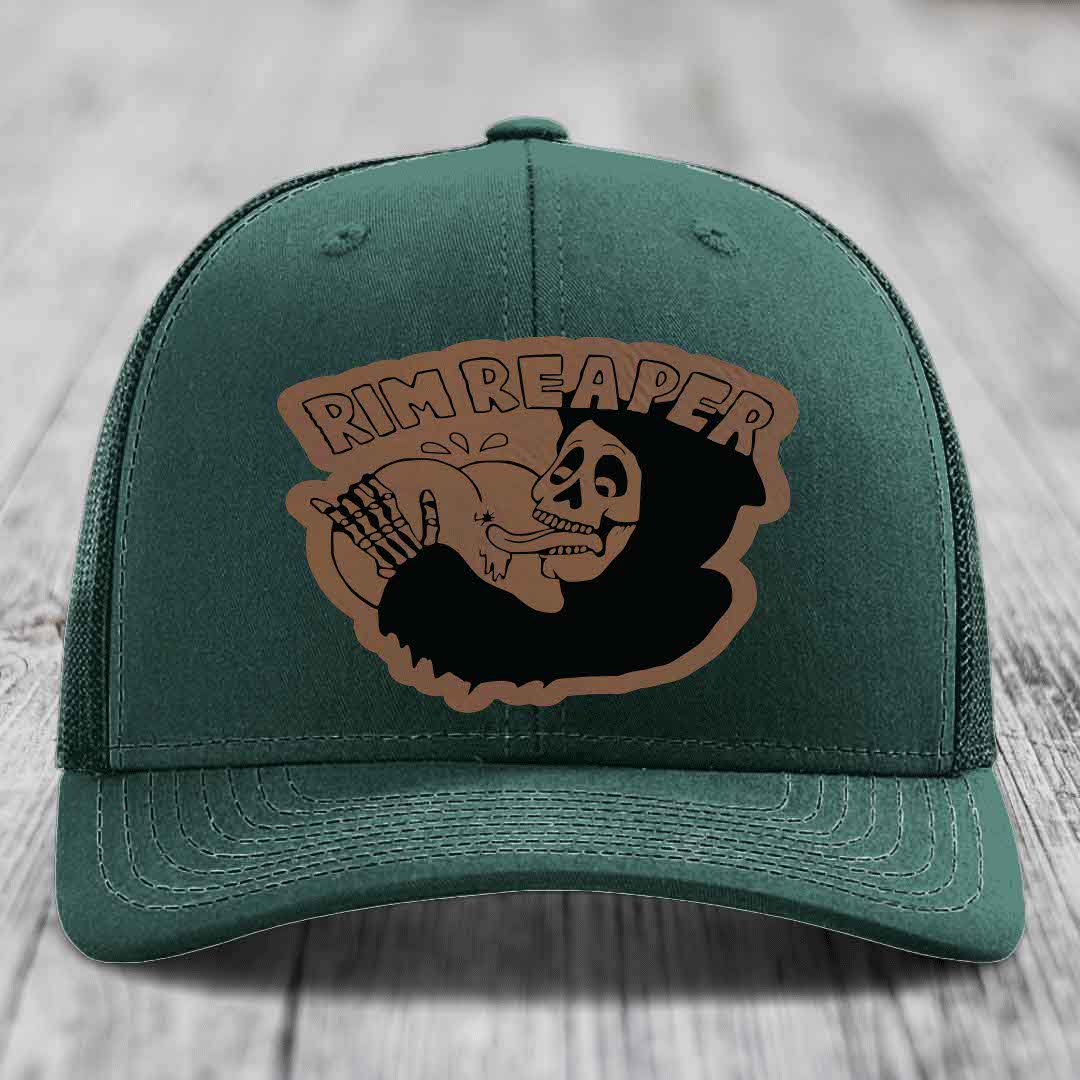 Green trucker hat with brown leather patch featuring skull and &