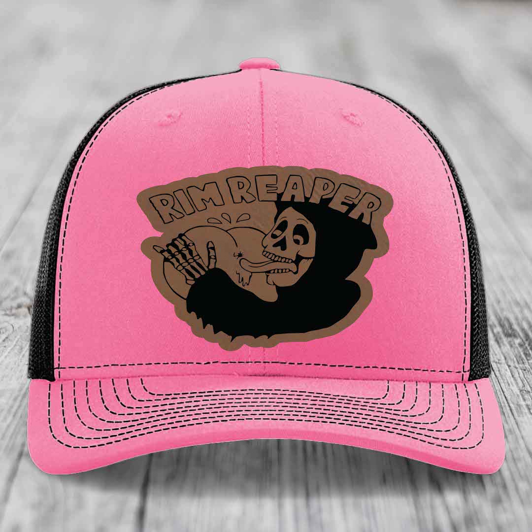 Pink trucker hat with black mesh back and brown leather patch featuring a skeleton holding a basketball and text &