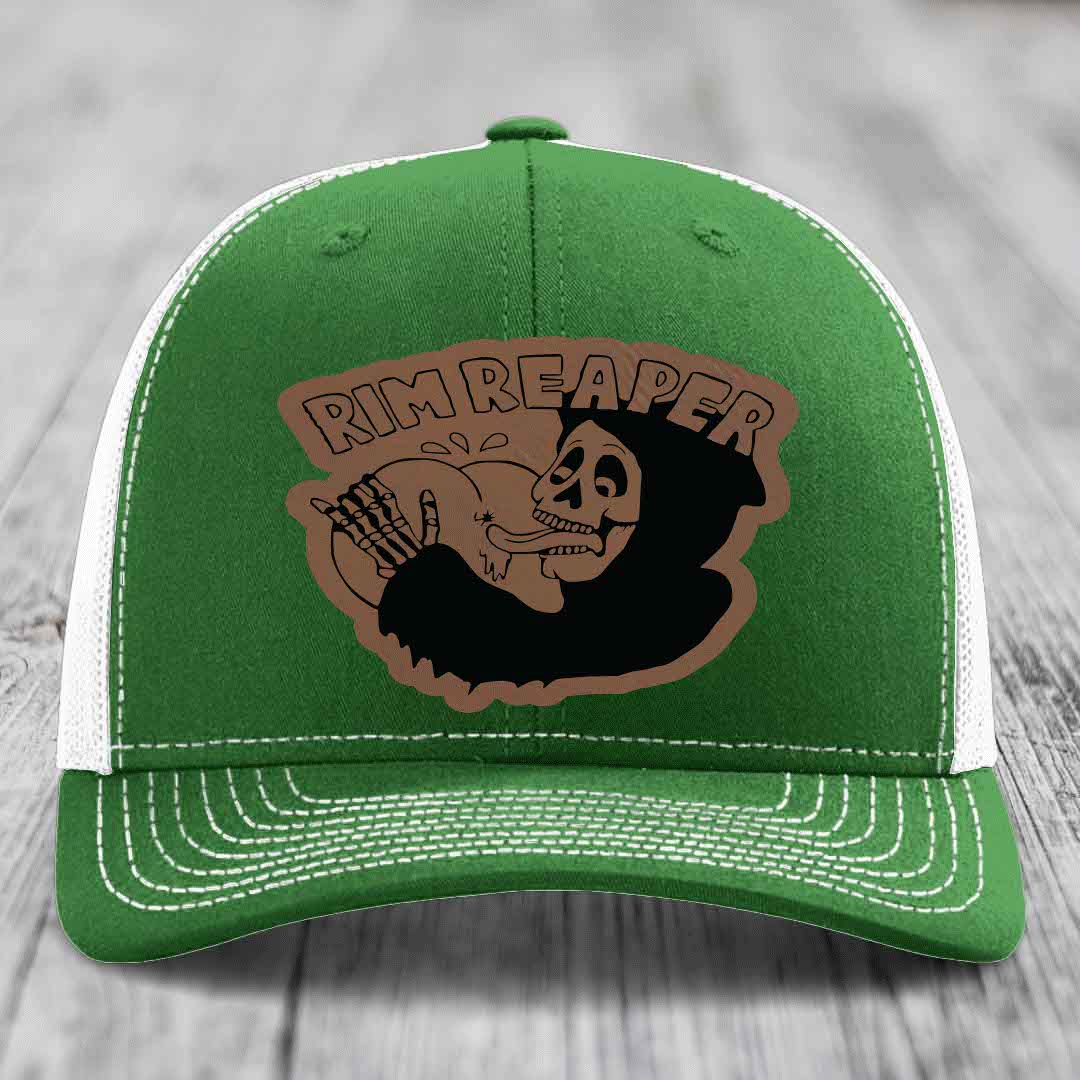 Green trucker hat with white mesh back and stitching, featuring a brown leatherette patch of a skeleton holding a basketball with &