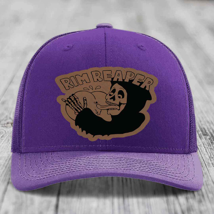 Purple trucker hat with brown leatherette patch featuring &