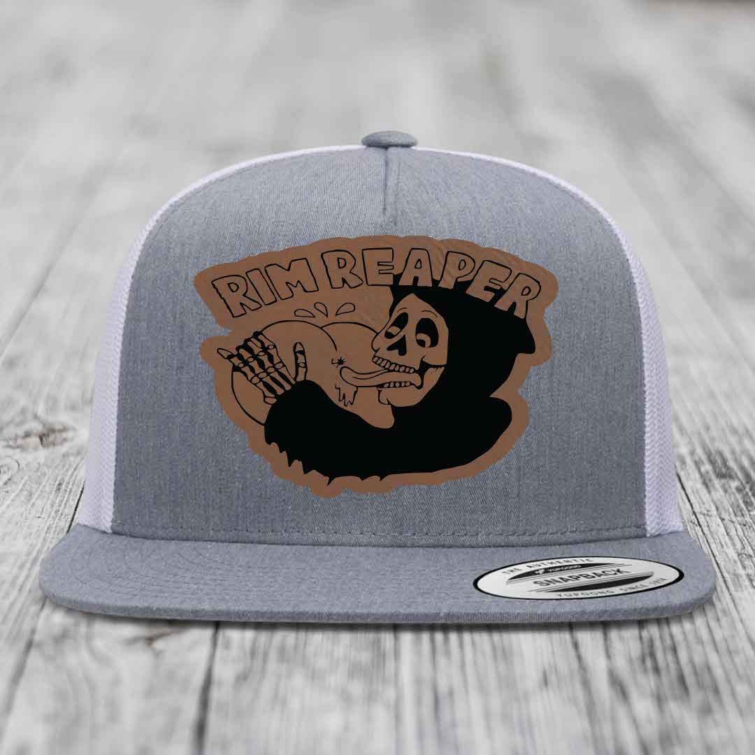 Grey trucker hat with brown leatherette patch featuring skull holding basketball and &