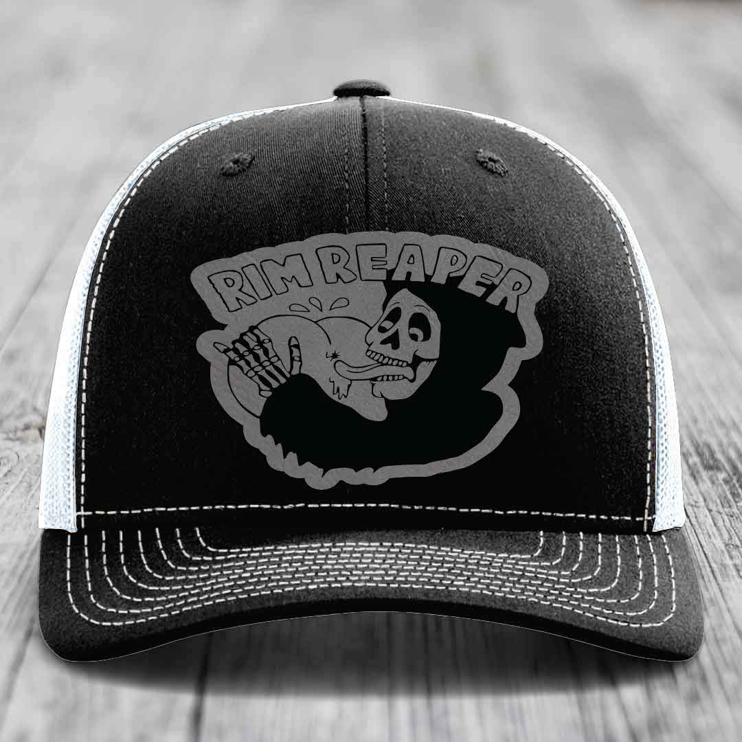 Black trucker hat with white stitching and a grey &