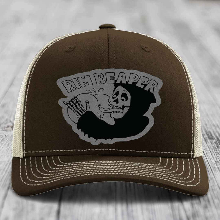 Brown trucker hat with white stitching and a gray &