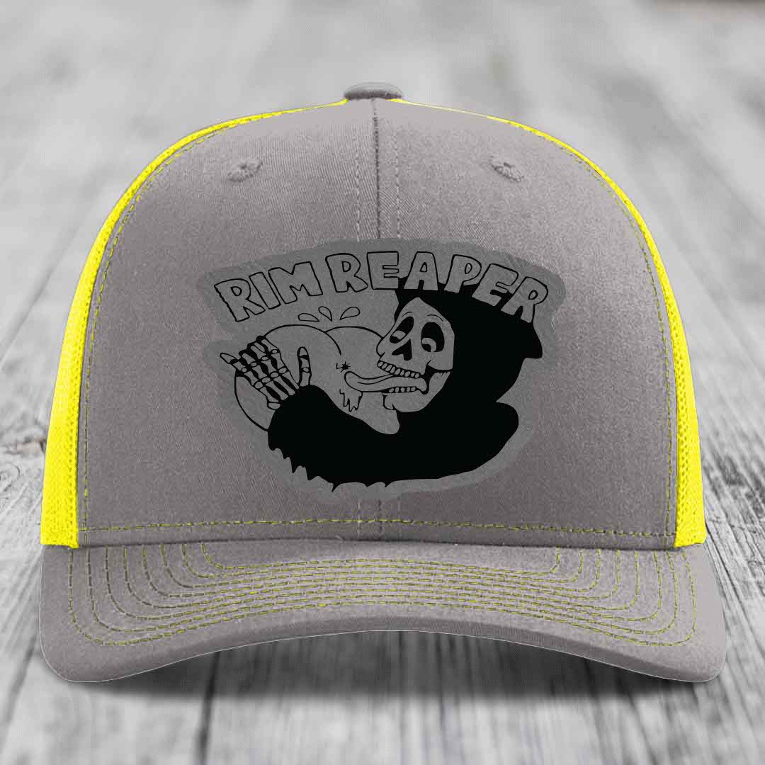 Grey trucker hat with yellow mesh and stitching, featuring a black &