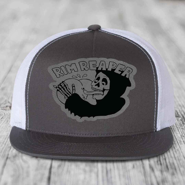 Grey and white trucker hat with black skull graphic and &