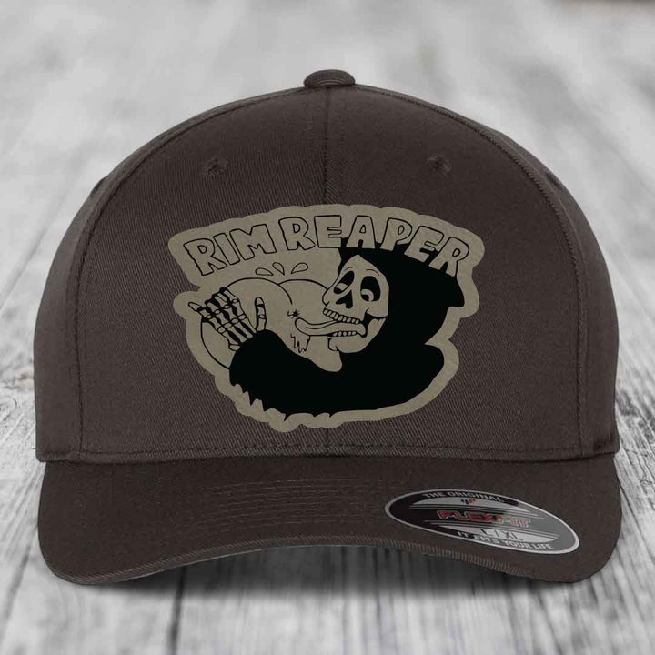 Dark brown Flexfit hat with a beige Rim Reaper skull patch on front.