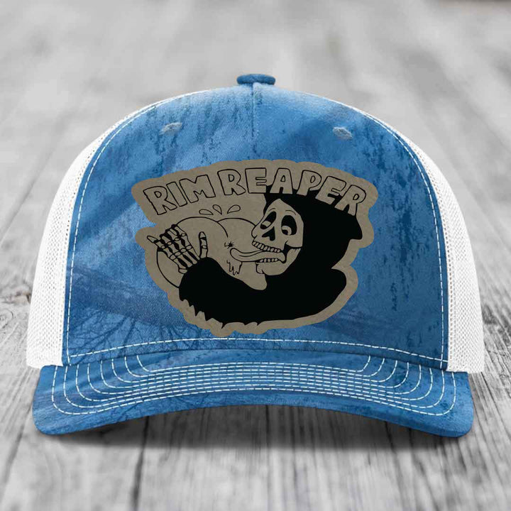 Blue and white trucker hat with a skull graphic and &